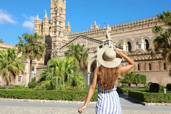Donna con cappello davanti alla Cattedrale di Palermo.