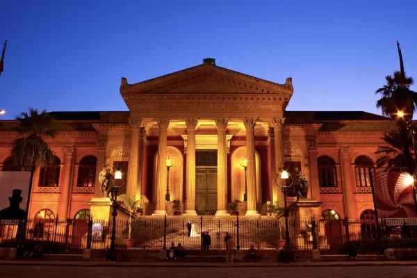 Facciata illuminata del Teatro Massimo di Palermo al crepuscolo.